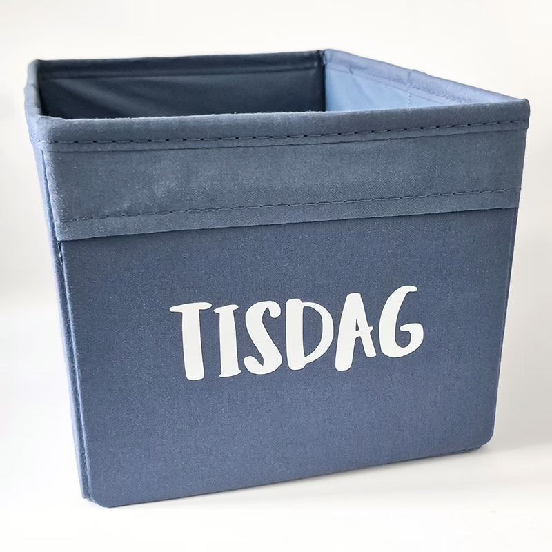 Liten Dröna-låda från IKEA märkt med veckodag och redo att fyllas med kläder eller annat som hör dagen till!