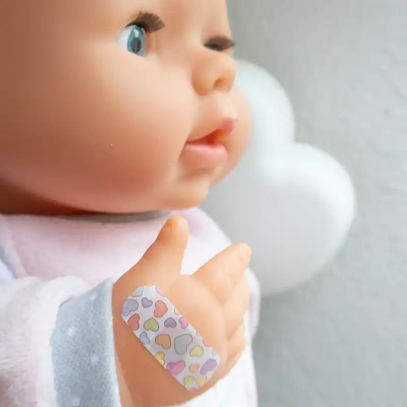 Dockan har fått ett plåster med hjärtan på handen.