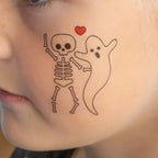 Skelettet och spöket är bästa kompisar. Motivet blir en alldeles lagom läskig tatuering till Halloween.