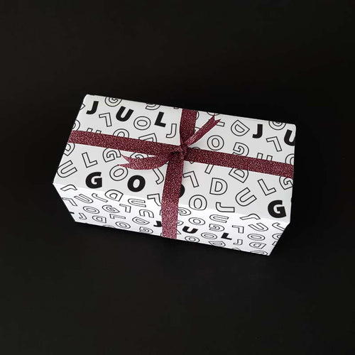 Christmas gift with wrapping paper that says MERRY CHRISTMAS