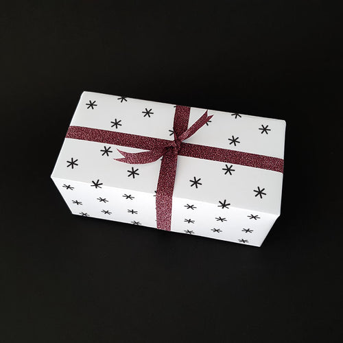Small Christmas gift wrapped in wrapping paper with snowflakes