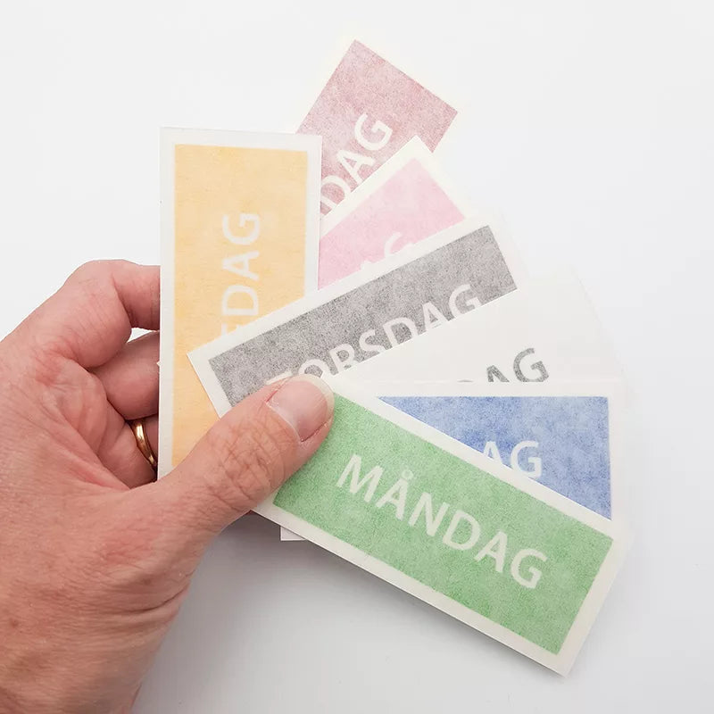 Stickers med veckodagarnas namn levereras med monteringstejp över motivet.