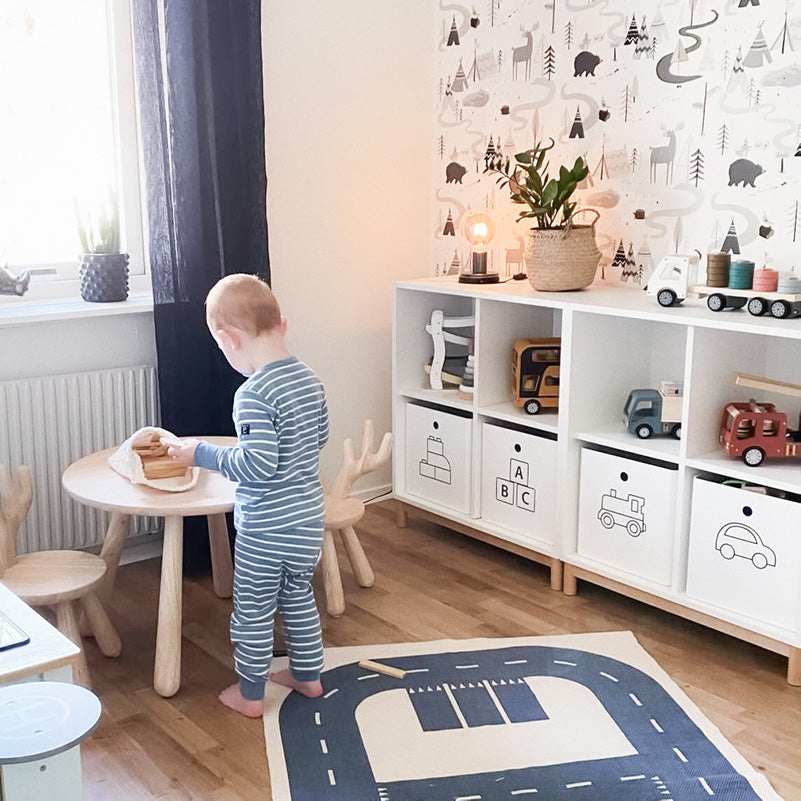 Kundbild från ett fint barnrum där leksakslådorna är uppmärkta med symboler för vad som förvaras i respektive låda.